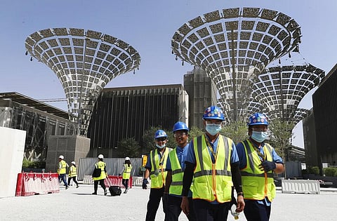 Technicians walk at the under construction site of the Expo 2020 in Dubai, United Arab Emirates. (File photo | AP)