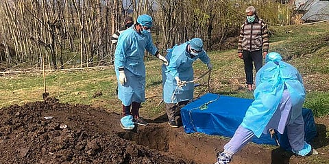 Family members of a man who died due to COVID-19 disease, bury his mortal remains at a graveyard, during a nationwide lockdown. (Photo| PTI)