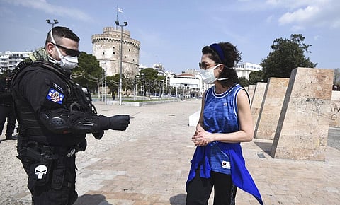 A policeman check a runner for valid documents during a lockdown order by the Greek government to control the spread of the new coronavirus in Greece. (Photo | AP)