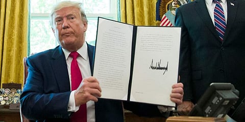 In this June 24, 2019, file photo, President Donald Trump holds up a signed executive order to increase sanctions on Iran, in the Oval Office of the White House in Washington. (Photo | AP)