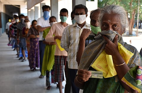 People waiting in queue to collect the token for special relief amount for COVID-19 at Rathinapuri Corporation Higher Secondary School in Coimbatore on Tuesday. (Photo | U Rakesh Kumar/EPS)