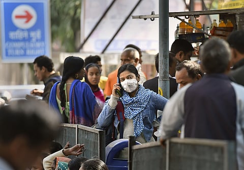 A young woman wearing a protective mask in the wake of novel coronavirus or COVID-19 outbreak speaks on the phone at RML Hospital in New Delhi. (Photo | PTI)