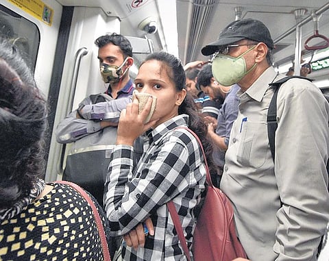 Metro riders wear protective masks in New Delhi. (Photo | PTI)