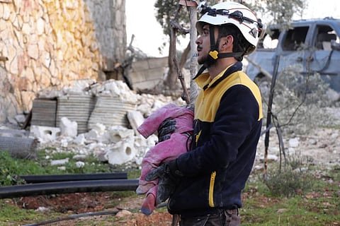 A Syrian White Helmet civil defense worker carries a child victim after Russian airstrikes hit Maaret Musreen village, in Idlib province. (Photo | AP)