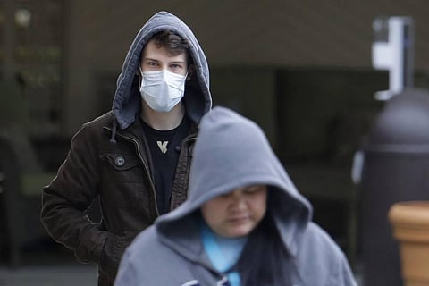 A man wearing a mask walks away from the entrance of the Life Care Center in Kirkland, Washington near Seattle. (Photo | AP)