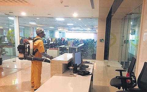 A worker spraying disinfectant at Building 20 of Raheja Mindspace in Hyderabad on Thursday
