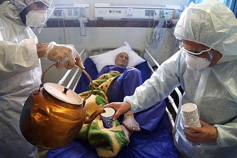 Paramedics treat a patient infected with COVID-19 at a hospital in Tehran. (Photo | AP)