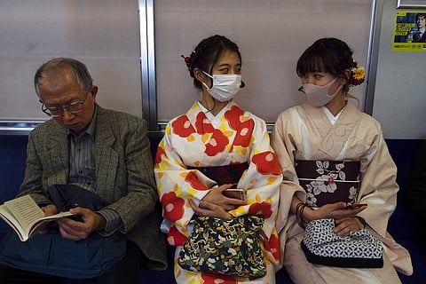 Two women wearing kimono chat in a train in Kyoto, Japan, March 18, 2020. (Photo | AP)