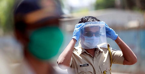 A police personnel wears plastic sheet on face while on duty during the nationwide lockdown in Mumbai. (Photo| ANI)