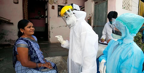 Medical officials wear protective gear interacts with local residents during going for the door to door to check for new COVID-19 cases in Ahmedabad. (Photo| ANI)