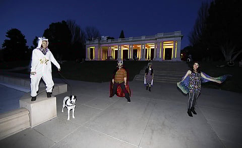 Irina Bocomolova and her dog, Darby, join Brice Maiurro, Shelsea Ochoa and Anna Beazer, from left, in a group howl in Cheesman Park in Denver. (Photo | AP)