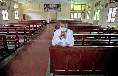 A Catholic priest V.M. Thomas prays in a church on Good Friday in Gauhati, India, Friday, April 10, 2020. (Photo | AP