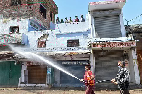 Lucknow Nagar Nigam workers sanitize an area sealed to contain the spread of COVID-19 during the ongoing nationwide lockdown in Lucknow Thursday April 9 2020. (Photo | PTI)