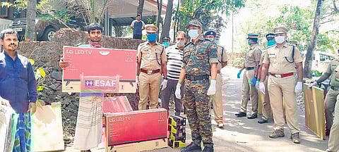 District Police Chief (Ernakulam Rural) K Karthik handing over an LED TV set to migrant workers in Perumbavoor