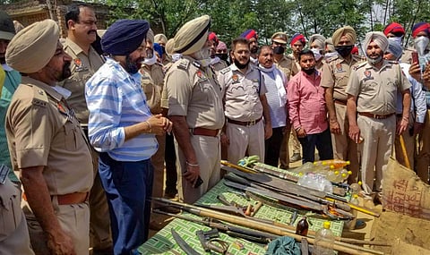 Patiala IG Jatinder Singh Aulakh and SSP Mandeep Singh Sidhu along with other police officers show sharp-edged weapons recovered from the arrested Nihangs at Balbera village in Patiala Sunday. (Photo | PTI)