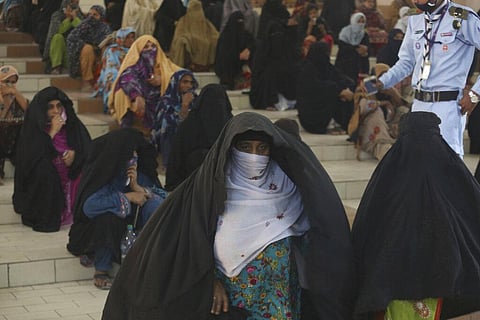 People wait to receive cash under the government's Ehsaas Emergency Cash Program for families in need, during a government-imposed nationwide lockdown to help contain the spread of the coronavirus, in Karachi, Pakistan, Tuesday, April 14, 2020. (Photo | A