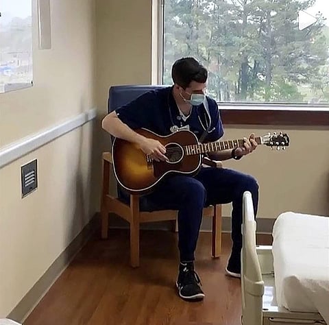 In this March 2020 image taken from video provided by Adam Blackerby, Michael Stramiello plays the guitar inside a hospital room in Benton, Arkansas. (Photo | AP)