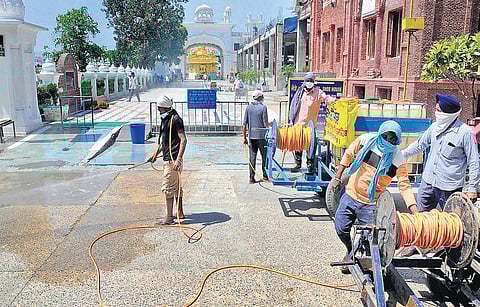 Golden Temple workers spray disinfectant on the premises in Amritsar during the nationwide lockdown | Pti