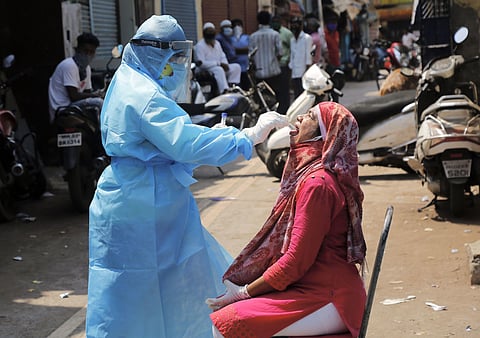 A healthcare worker collects swab sample of a person for COVID-19 test during the nationwide lockdown. (Photo | PTI)