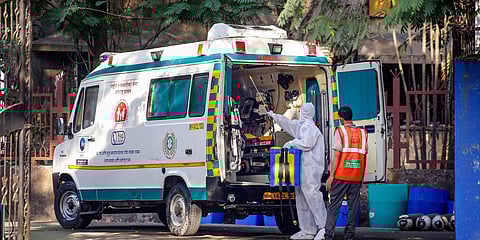 A civic worker sprays disinfectant inside an ambulance after transporting a COVID19 positive patient at Poddar Hospital, in Mumbai. (Photo| PTI)