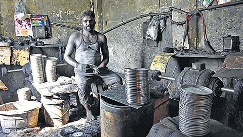 File picture of a labourer making aluminium plates