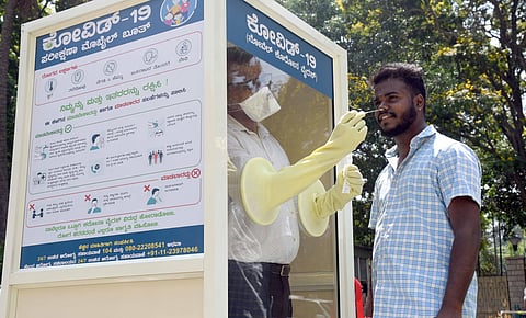 A health worker collects a man’s nasal swab at a mobile testing kiosk opened at the CM’s residence, in Bengaluru on Thursday | Nagaraja Gadekal