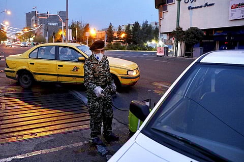 A Revolutionary Guard member disinfects a car to help prevent the spread of the new coronavirus in downtown Tehran, Iran. (Photo | AP)