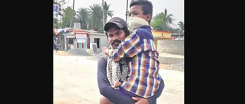 Chakradhar holds his physically challenged son in arms