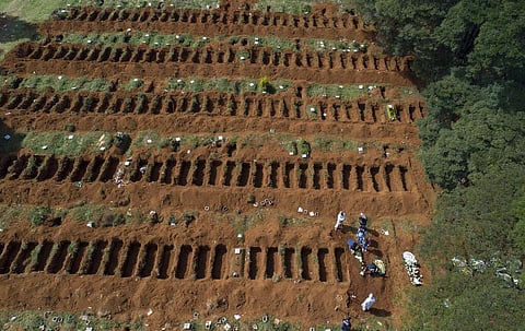 Cemetery workers in protective clothing bury a person at the Vila Formosa cemetery in Sao Paulo, Brazil. (Photo | AP)