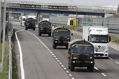 In this Thursday, March 26, 2020 file photo, military trucks moving coffins of deceased people line up on the highway next to Ponte Oglio, near Bergamo, one of the areas worst hit by the coronavirus infection, on their way from Bergamo cemetery to a crema