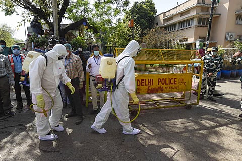 Health workers prepare to sanitise an area near Nizamuddin mosque, after people who attended the religious congregation at Tabligh-e-Jamaat's Markaz, tested postive for COVID-19, in New Delhi. (Photo | PTI)