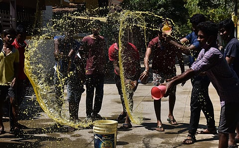 Youngsters in Perambur spraying turmeric water on the road as a precautionary measure. (Photo | EPS/P Jawahar)