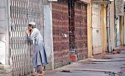 A boy takes a peek into an empty mosque which was closed due to the lockdown, at Avenue Rd in Bengaluru on Wednesday | Nagaraja Gadekal