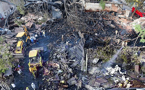 Fire personal trying to a dose off at bamboo bazaar where 13 shops were gutted. (Photo | Shriram BN, EPS)