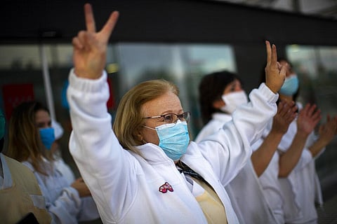 Health workers gesture in support of the medical staff that are working on the COVID-19 virus outbreak in Spain. (Photo | AP)