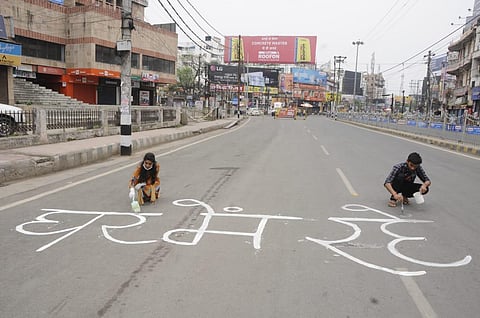 Youths writing slogans on deserted road in patna in support of lockdown. (Photo| Ranjit K Dey)