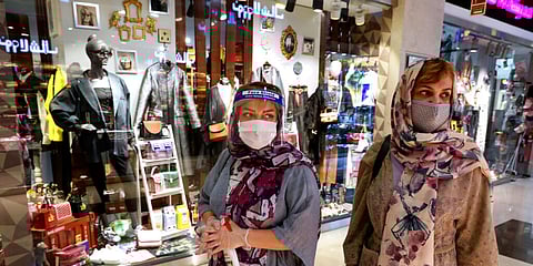Women wearing protective face masks and gloves to help prevent the spread of the coronavirus shop at Tehran, Iran. (Photo | AP)