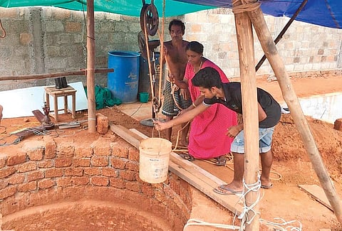 Nedumbassery native Alias A M with wife Lissy and younger son Bibin at the well near their new house. The well was dug up by Alias during the lockdown in just 17 days | Express