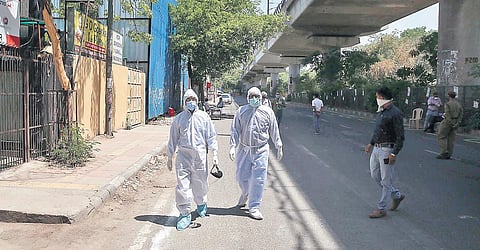 Members of a medical team wearing protective gear walk past a coronavirus testing camp. (Photo | Shekhar Yadav, EPS)