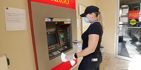 Leymar Navas, who used to work at a restaurant, cleans an ATM at a bank. (Photo| AP)