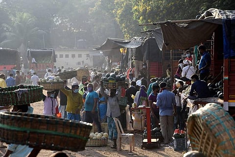 Workers violate social distancing norms as they unload fruits from trucks at APMC market during the nationwide lockdown to curb the spread of coronavirus in Navi Mumbai. (Photo | PTI)