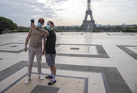 People wear masks to protect against the spread of the coronavirus take a selfie at Tocadero square close to the Eiffel Tower in Paris, Friday, April 24, 2020. (Photo | AP)