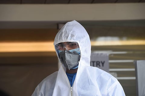 A health worker wearing a protective suit waits for samples from people for COVID -19 tests at a centre in New Delhi Thursday April 23 2020. (Photo | PTI)