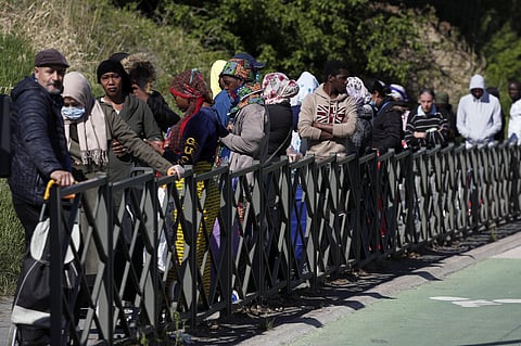 Residents line up during a distribution to collect soap, vegetables, fruits and other staples distributed by volunteers from community organizations of ACLEFEU in Clichy-sous-Bois, a suburb north of Paris. (Photo | AP)