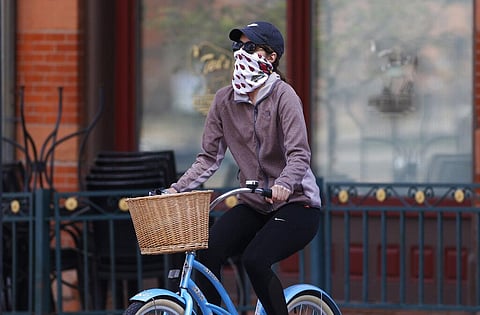 bicyclist wears face protection against the new coronavirus while pedaling through Larimer Square early Saturday, April 25, 2020, in downtown Denver. (Photo | AP)