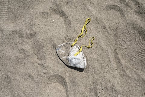 An N95 protective face mask lies in the sand on Brighton Beach in the Brooklyn borough of New York. (Photo | AP)