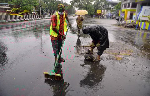 Sanitation workers sweep away a waterlogged road at Mogappair in Chennai on Sunday morning. (Photo | EPS/ DEBADATTA MALLICK)