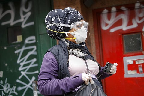 A woman wearing a protective past and googles walks along Canal Street, Monday, April 27, 2020, in the Manhattan borough of New York. (Photo | AP)