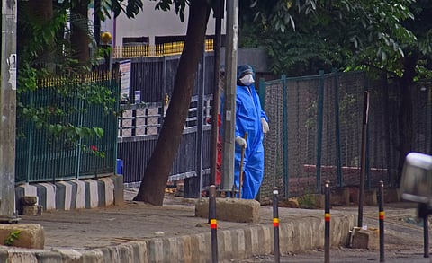 A health worker is seen standing outside Victoria hospital where a COVID-19 patient committed suicide on Monday in Bengaluru. (Photo | Pandarinath B/EPS)