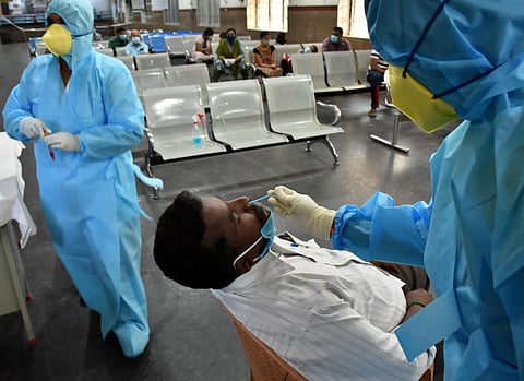 Health department staff collecting swabs from police personnel and their family members to detect Coronavirus infection through RT-PCR method at Coimbatore Railway Station on Monday. (Photo | U Rakesh Kumar/EPS)